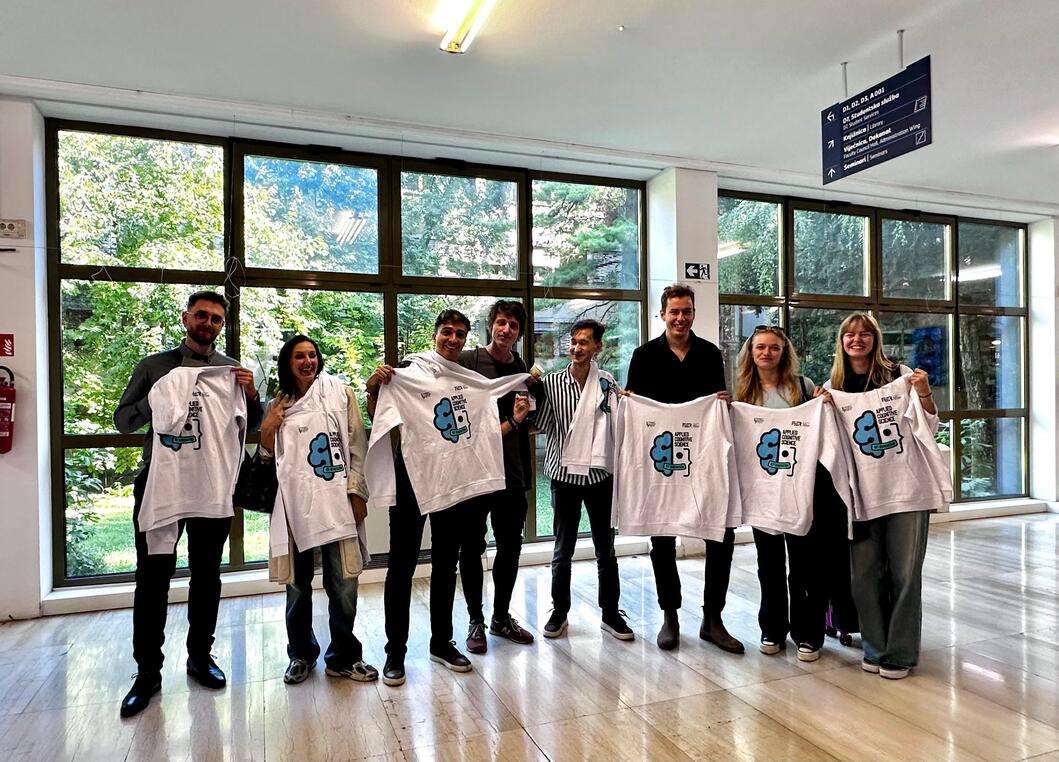 The first generation of graduates holding up Applied Cognitive Science sweatshirts in the faculty foyer